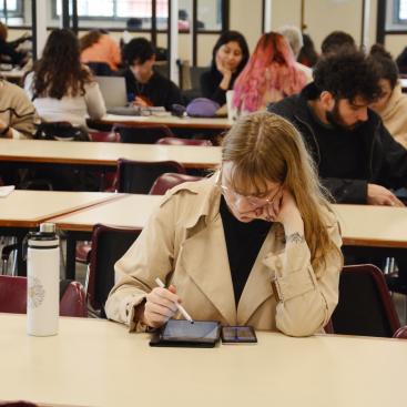 Una estudiante lee concentrada en la biblioteca de Puan. 