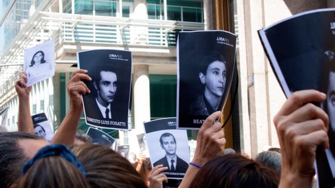 Manifestantes sostienen fotografías de detenidos desaparecidos de Filo. 