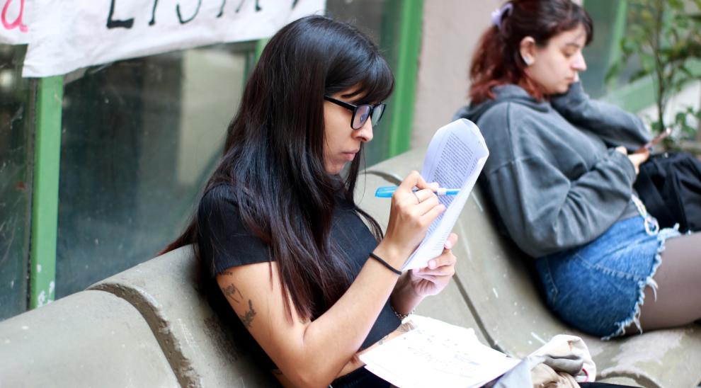 Estudiante leyendo en el patio de Puan. 