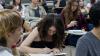 Estudiante escribiendo en un aula de la sede Puan. 